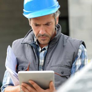 Unternehmer auf der Baustelle benutzt ein Tablet wegen der Automatisierung von Geschäftsprozessen